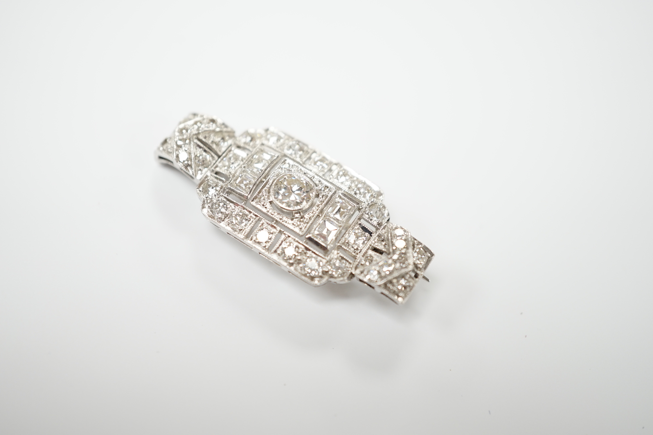 An Art Deco style white metal and diamond cluster set pendant brooch, overall 38mm, gross weight 5.9 grams.